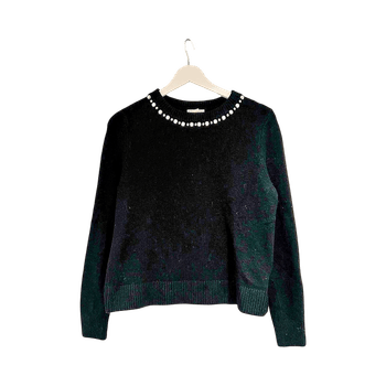 Musta neulepaita helmillä