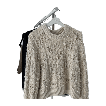 beige neulepusero helmikoristeilla