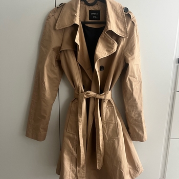 beige trenssitakki vyöllä