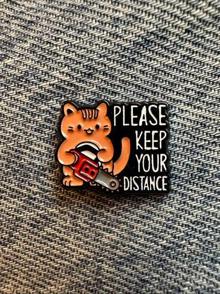 Small Cat chainsaw enamel pin