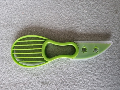 Green plastic avocado preparation tool with knife 